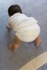Infant in diaper standing up on floor — Stock Photo
