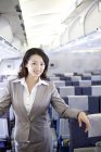 Femme d'affaires chinoise posant dans l'avion — Photo de stock