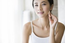 Young chinese woman applying face powder — Stock Photo