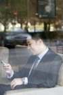 Китайський бізнесмен за допомогою смартфона в кафе — стокове фото