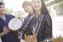 Amici cinesi che suonano strumenti musicali per strada — Foto stock