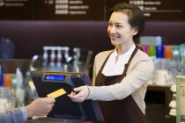 Cliente maschio che paga con carta di credito in caffetteria — Foto stock