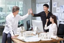 Male architects making high-five in office — Stock Photo