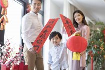 Família alegre com bandeiras decorativas e lanterna no Ano Novo Chinês — Fotografia de Stock