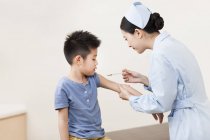 Enfermeira chinesa dando injeção menino — Fotografia de Stock