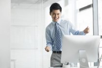 Homme d'affaires chinois acclamant et dansant au bureau — Photo de stock