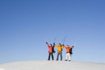 Amigos chineses posando com bastões de esqui no ar — Fotografia de Stock