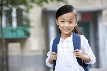 Chinesisches Schulmädchen mit Rucksack steht auf Straße — Stockfoto