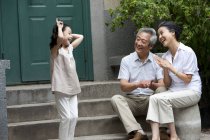 Cinese elementare età ragazza giocare con nonni su strada — Foto stock