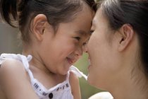 Chinese mother and daughter rubbing noses, close-up — Stock Photo