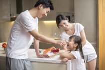 Китайський батько годування дочка фрукти кухні — стокове фото