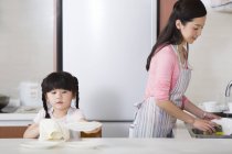 Китайський мати і дочка прання та сушіння посуду — стокове фото