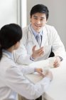Chinesische Ärzte unterhalten sich am Krankenhaustisch bei Kaffee — Stockfoto