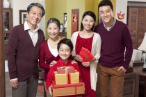 Petit garçon avec des parents visitant les grands-parents avec des cadeaux pendant le Nouvel An chinois — Photo de stock