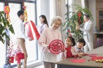 Cheerful family decorating home for Chinese New Year — Stock Photo