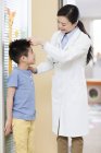 Cinese medico misurazione ragazzo altezza — Foto stock