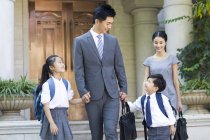 Chinese business couple with children walking hand in hand at street — Stock Photo