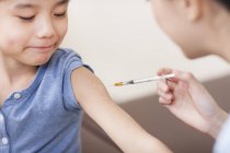 Infirmière donnant injection garçon chinois — Photo de stock
