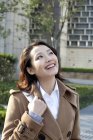 Portrait of happy Chinese woman in city — Stock Photo