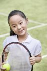 Portrait of little Chinese girl with tennis racket — Stock Photo