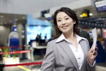 Китайская предпринимательница держит билет в аэропорту — стоковое фото