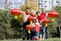 Китайская семья из нескольких поколений с китайскими фонарями в парке — стоковое фото