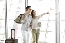 Chinesisches Paar steht am Flughafen und betrachtet die Aussicht — Stockfoto