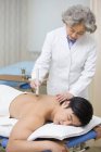 Female chinese doctor giving moxibustion therapy to male patient — Stock Photo