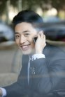 Hombre de negocios chino hablando por teléfono en la cafetería - foto de stock