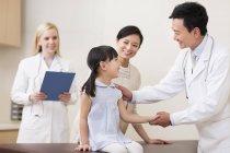 Chinese male doctor talking with girl in hospital — Stock Photo