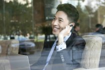 Uomo d'affari cinese che parla al telefono nel caffè — Foto stock