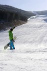 Сноубордист смотрит на вид с протянутой рукой — стоковое фото