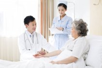 Medico cinese che prende il polso del paziente in ospedale — Foto stock