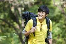 Turista chinês com mochila em madeiras — Fotografia de Stock