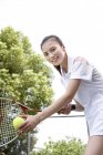 Joven mujer china jugando tenis - foto de stock