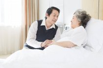 Chinese senior man visiting wife in hospital — Stock Photo