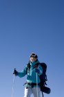 Femme chinoise posant avec équipement de ski sur fond bleu — Photo de stock