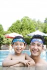 Китайский отец и сын в плавательных очках в бассейне — стоковое фото