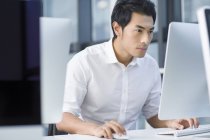 Chinese businessman using computer in office — Stock Photo