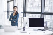 Chinese businesswoman at workplace looking in camera — Stock Photo