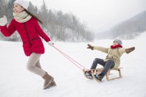 Chinese mother pulling son on sled — Stock Photo