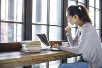 Donna cinese che studia con computer portatile in caffè — Foto stock