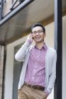 Chinese man talking on phone on street — Stock Photo