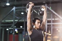 Chinês homem formação com kettlebells no crossfit ginásio — Fotografia de Stock