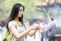 Chinese woman burning incense in Lama Temple — Stock Photo