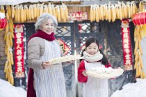 Grandmother and granddaughter posing with Chinese dumplings — Stock Photo