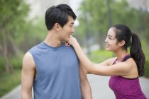 Chinese couple of joggers taking break and talking — Stock Photo