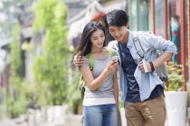 Китайская пара использует смартфон на улице Пекина — стоковое фото