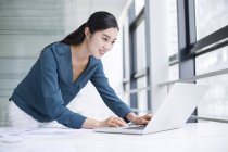 Китайская предпринимательница использует ноутбук в офисе — стоковое фото