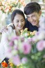 Chinese couple choosing flowers in store — Stock Photo